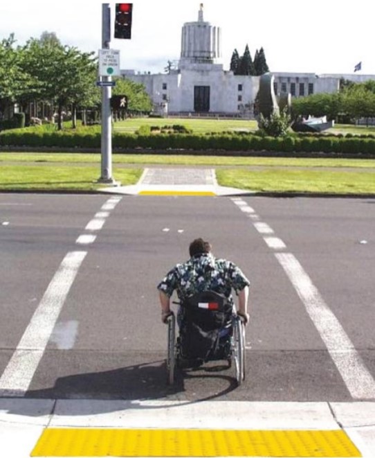 disabled person in wheelchair using crosswalk image
